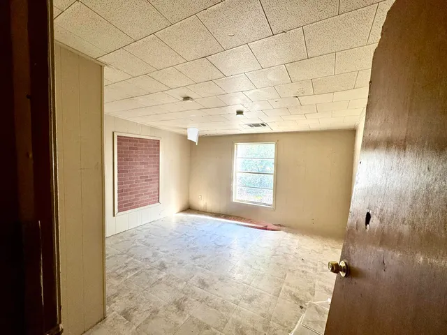 a view of a hallway with wooden floor and cabinet