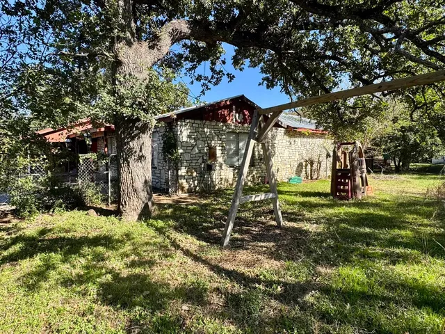 a view of a park with swings and a tree