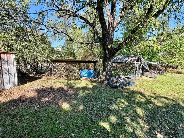 a view of a yard with table and chairs and a large tree