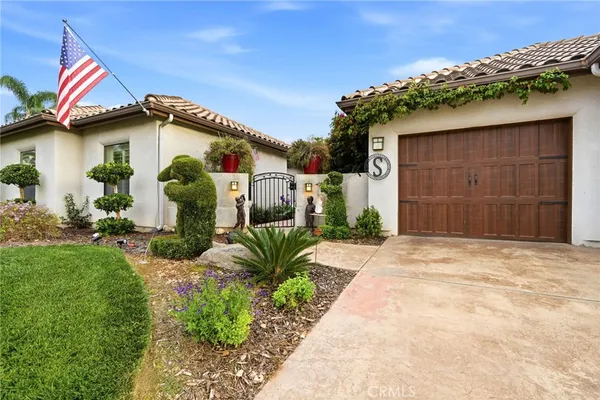 a house with a flower garden and potted plants