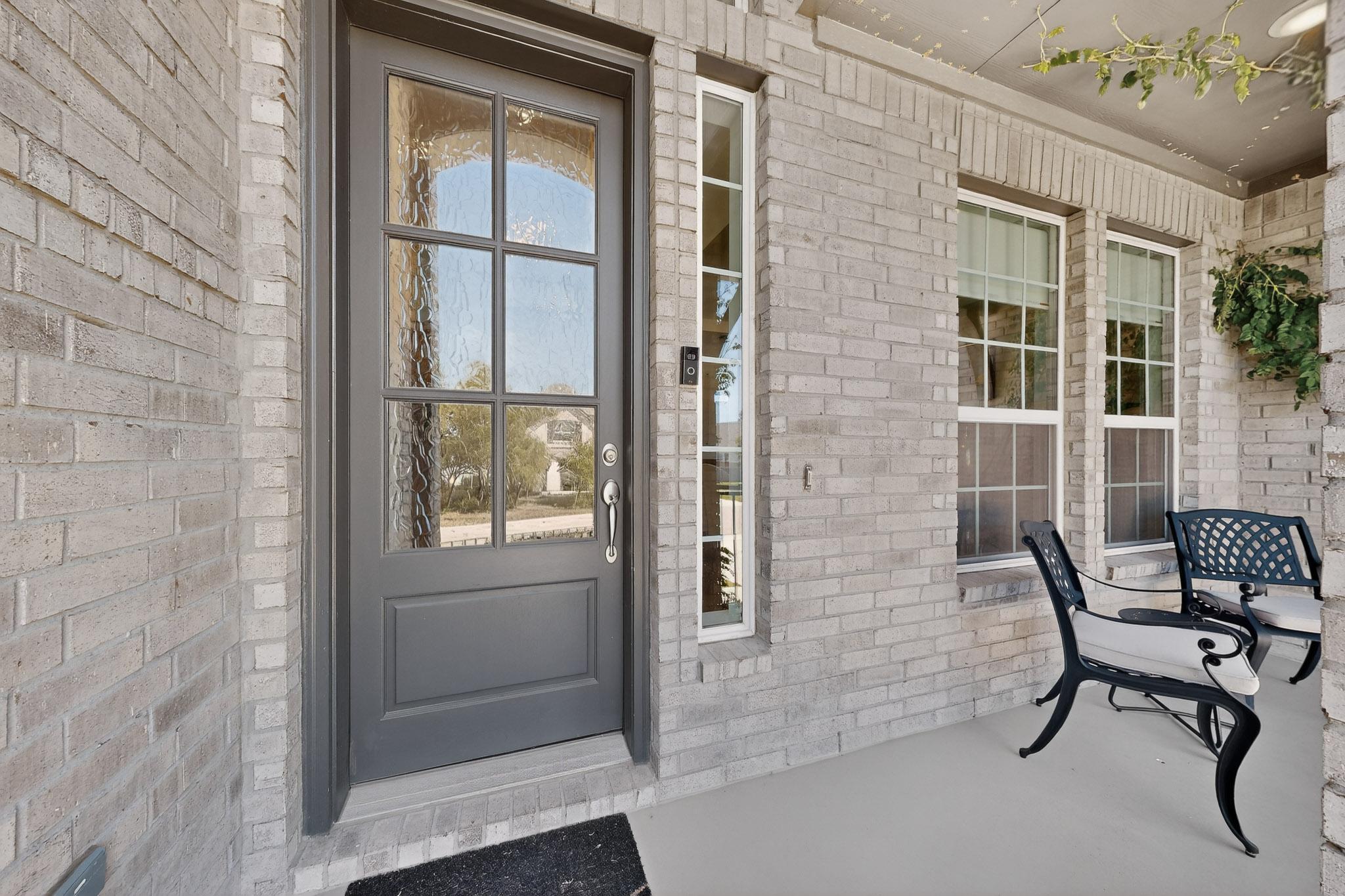 249 Running Bird Road Austin, TX 78737 - Photo 3 of 40 a view of a brick house with chairs and table in front of house