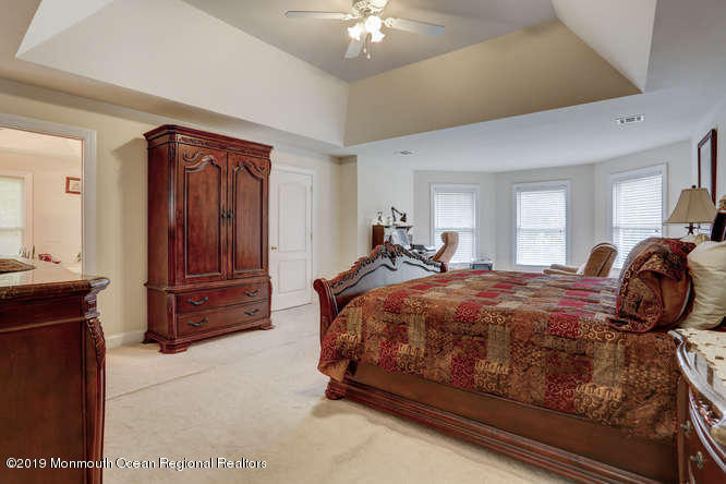 58 Fort Plains Road Howell, NJ 07731 - Photo 15 of 33 a bedroom with a bed and a chandelier