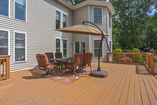 58 Fort Plains Road Howell, NJ 07731 - Photo 31 of 33 a view of a patio with table and chairs and wooden floor