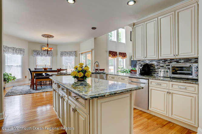 58 Fort Plains Road Howell, NJ 07731 - Photo 6 of 33 a kitchen with stainless steel appliances granite countertop a stove top oven a sink dishwasher and cabinets with wooden floor