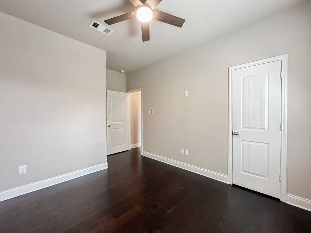 10 Pilot Rock Place Tomball, TX 77375 - Photo 17 of 38 an empty room with wooden floor chandelier fan and windows