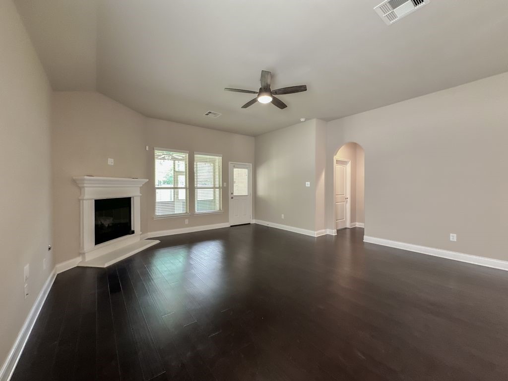 10 Pilot Rock Place Tomball, TX 77375 - Photo 24 of 38 an empty room with wooden floor fireplace and windows
