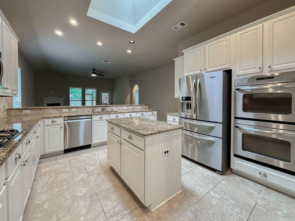 10 Pilot Rock Place Tomball, TX 77375 - Photo 10 of 38 a kitchen with granite countertop a sink stainless steel appliances and cabinets