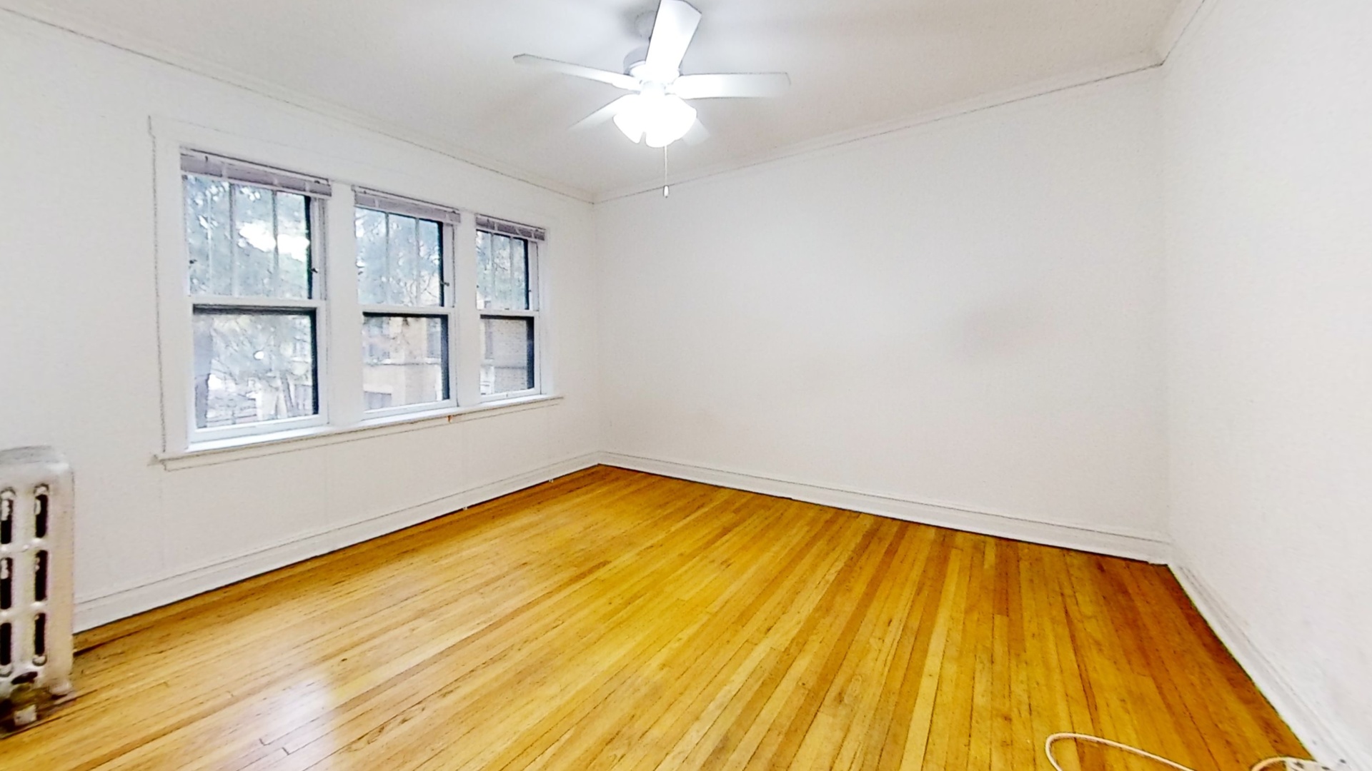1337 West Addison Street, Unit 1A Chicago, IL 60613 - Photo 2 of 9 a view of empty room with wooden floor and fan