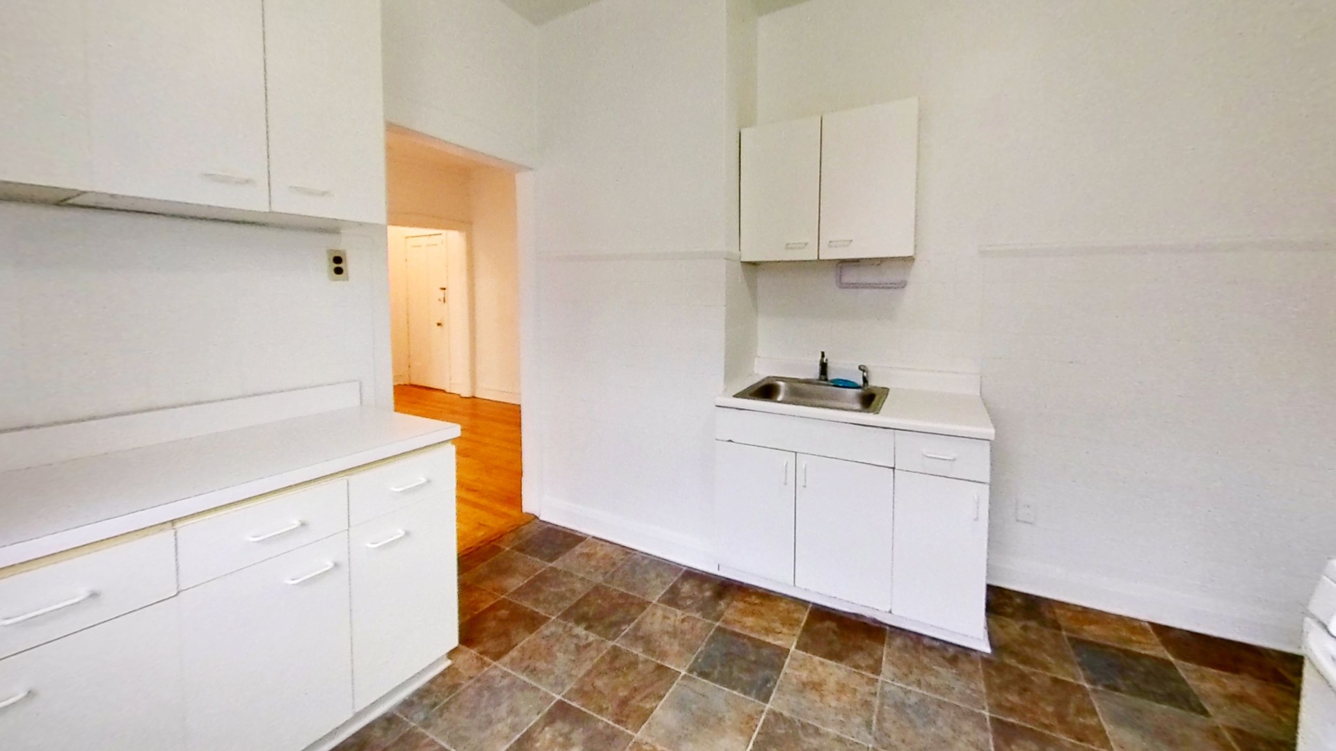 1337 West Addison Street, Unit 1A Chicago, IL 60613 - Photo 5 of 9 a kitchen with granite countertop white cabinets and white appliances