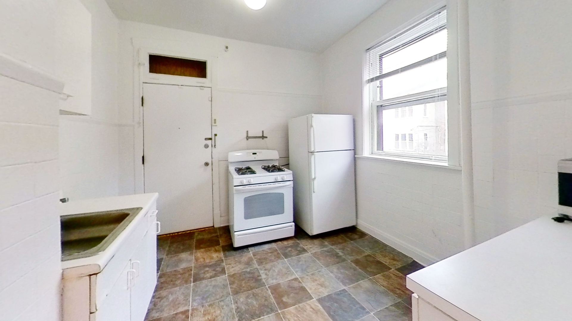 1337 West Addison Street, Unit 1A Chicago, IL 60613 - Photo 6 of 9 a kitchen with white cabinets and white appliances
