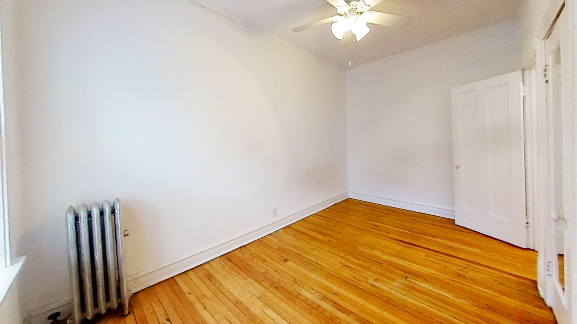 1337 West Addison Street, Unit 1A Chicago, IL 60613 - Photo 7 of 9 a view of a room with wooden floor and a ceiling fan