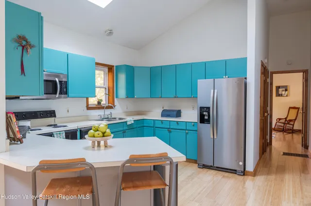 a kitchen with a refrigerator a stove a sink cabinets and a dining table