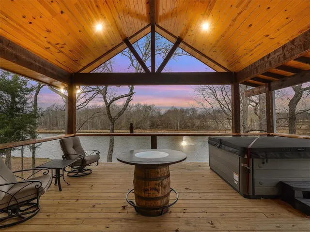 a view of a patio with table and chairs with wooden floor and fence