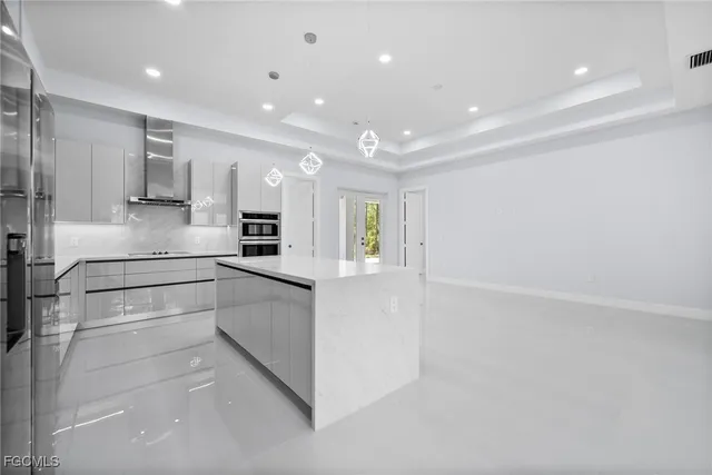 a large white kitchen with white cabinets and stainless steel appliances