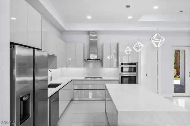 a kitchen with stainless steel appliances kitchen island granite countertop a refrigerator and a sink