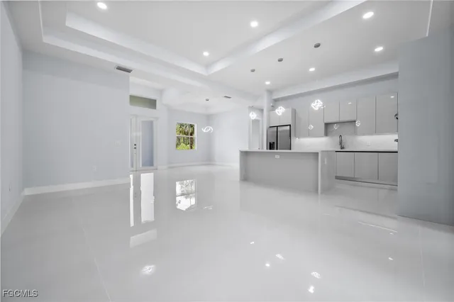 a large white kitchen with stainless steel appliances lots of white cabinets