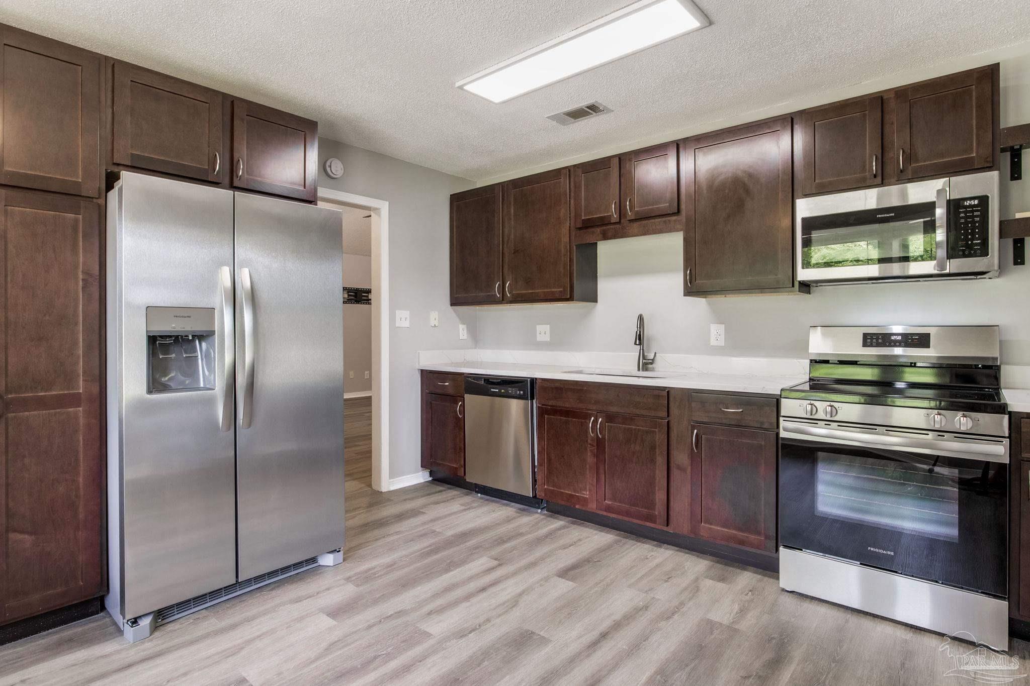 4921 Jennifer Lane Pace, FL 32571 - Photo 8 of 36 a kitchen with stainless steel appliances granite countertop a refrigerator a sink a stove and cabinets