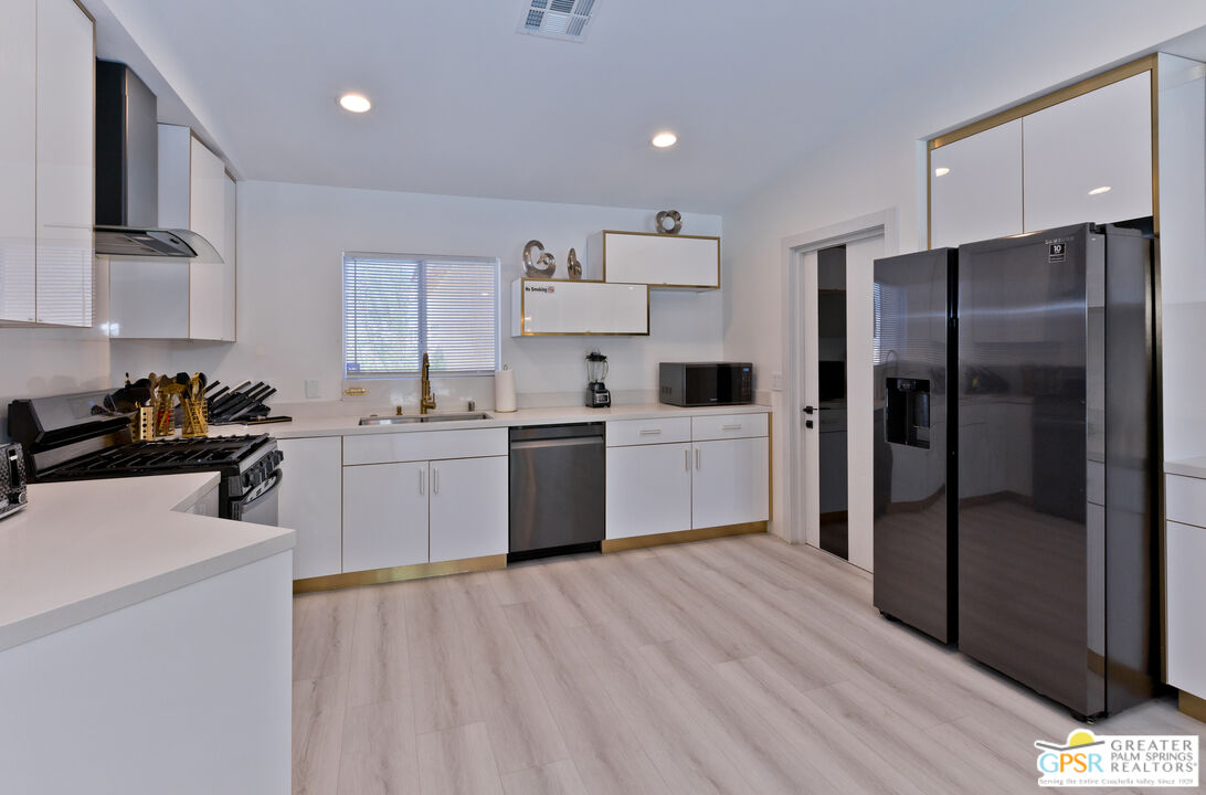 12800 Miracle Hill Road Desert Hot Springs, CA 92240 - Photo 18 of 51 a kitchen with stainless steel appliances a refrigerator sink and cabinets