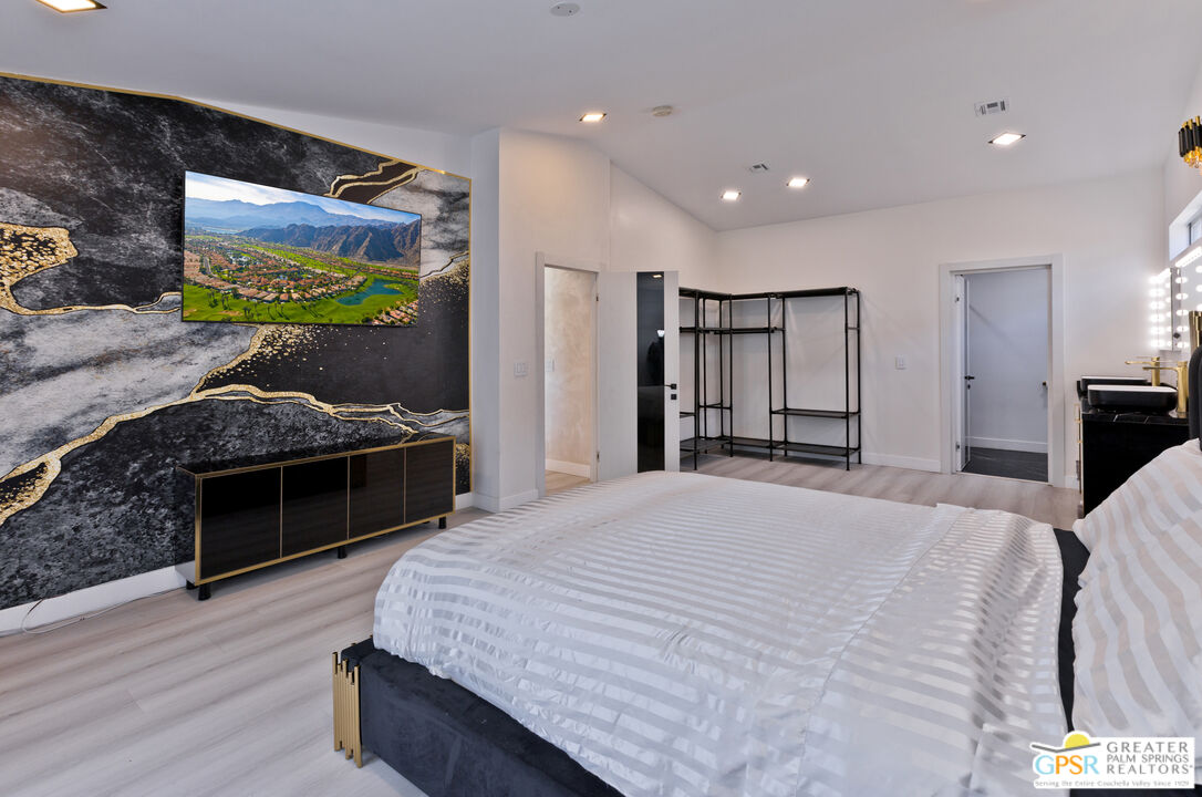 12800 Miracle Hill Road Desert Hot Springs, CA 92240 - Photo 23 of 51 a spacious bedroom with a bed and a flat screen tv