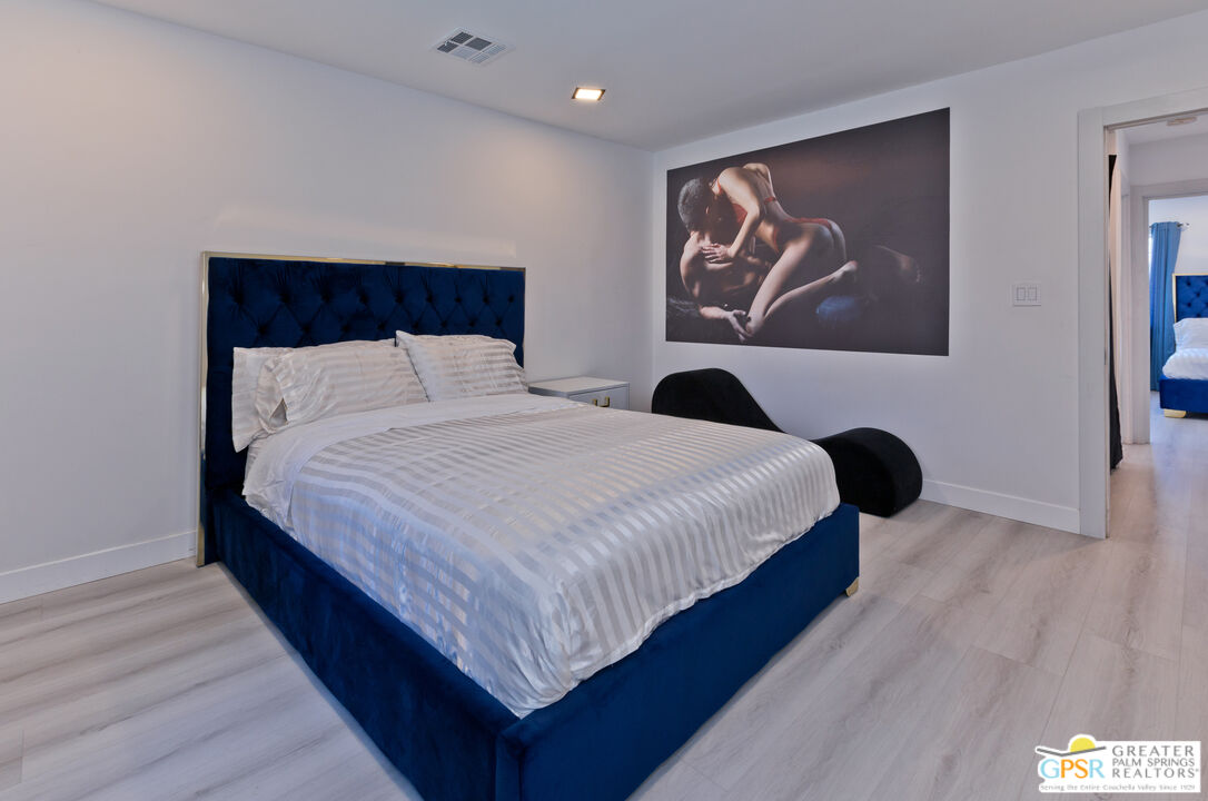 12800 Miracle Hill Road Desert Hot Springs, CA 92240 - Photo 32 of 51 a bedroom with bed and wall painting with wooden floor
