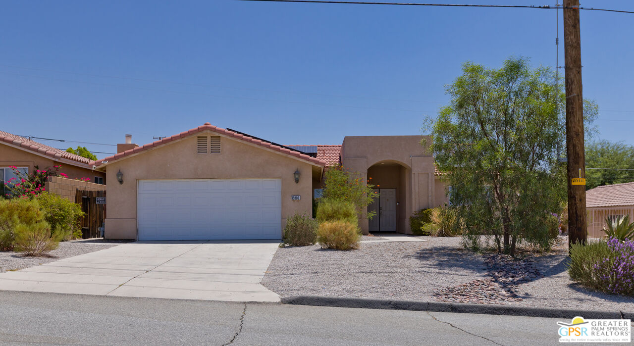 12800 Miracle Hill Road Desert Hot Springs, CA 92240 - Photo 7 of 51 a front view of a house with a yard and garage