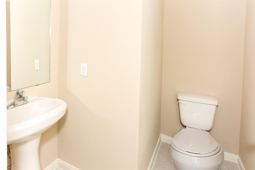 1421 Park Trails Boulevard Princeton, TX 75407 - Photo 13 of 17 a white toilet sitting next to a bathroom sink