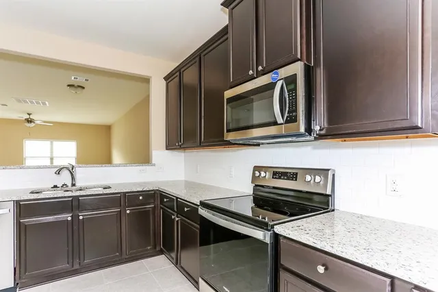 a kitchen with a sink stove and microwave
