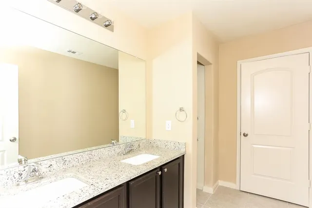 a bathroom with a granite countertop sink and a mirror