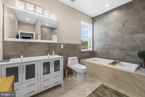 a bathroom with a double vanity sink a toilet and mirror