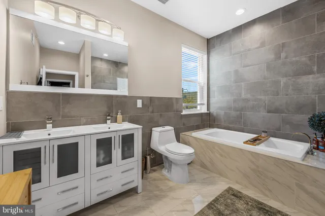 a bathroom with a double vanity sink a toilet and mirror
