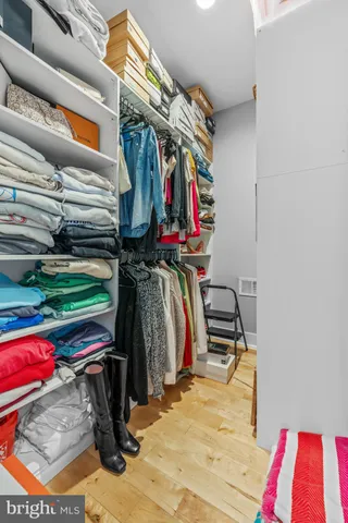 a view of walk in closet with clothes and shoes
