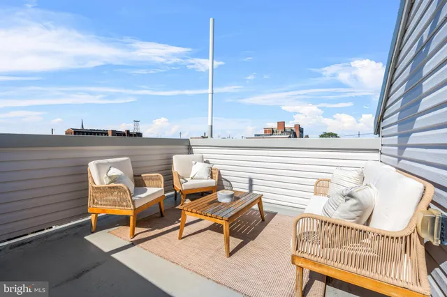 a roof deck with outdoor seating and city view