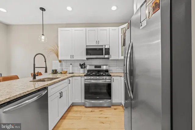 a kitchen with a sink stainless steel appliances and cabinets