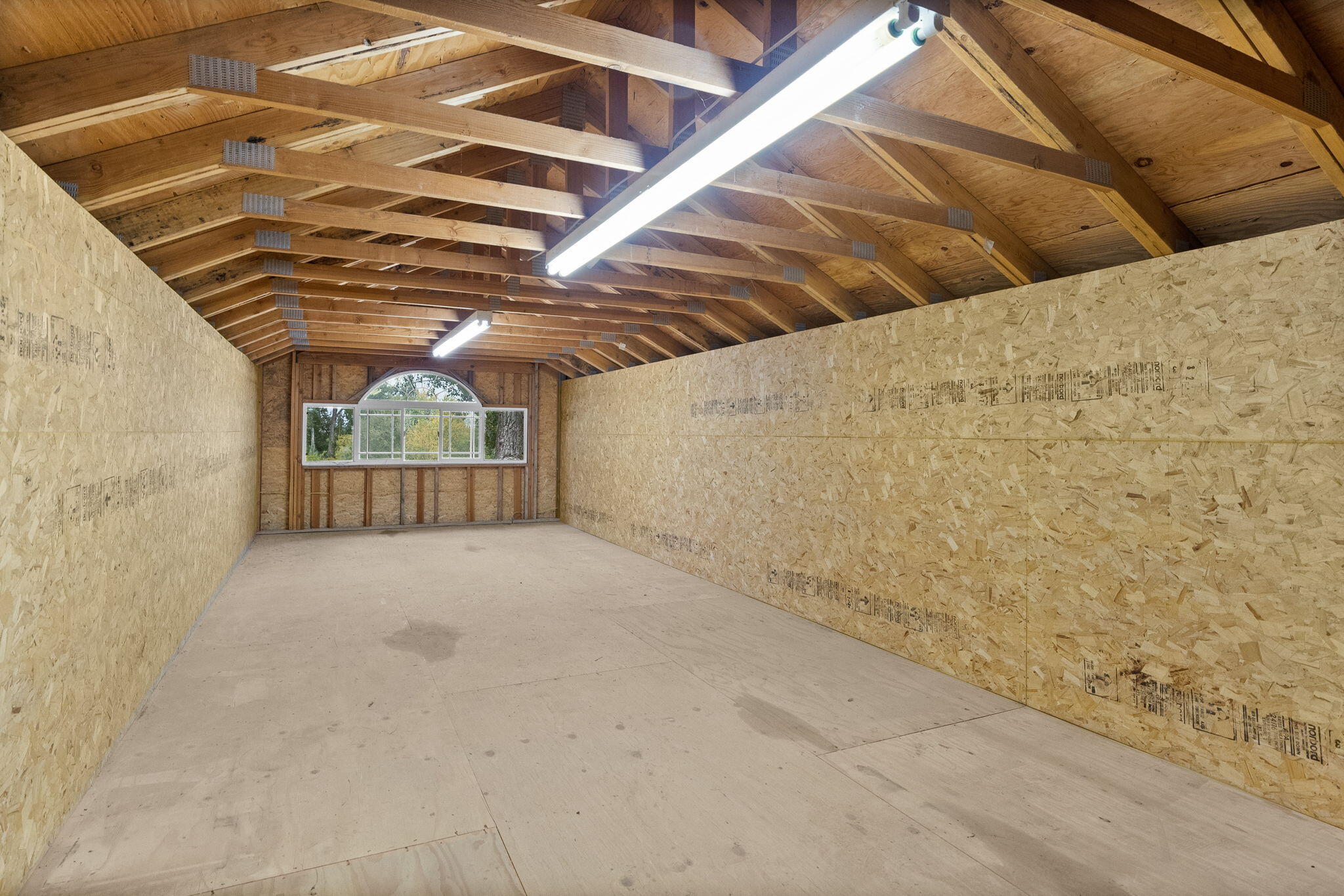 21925 Bear Creek Road Bend, OR 97702 - Photo 75 of 104 Second level of the shop has a large window, is over head high and great for storage or ready for a conversion to useable space