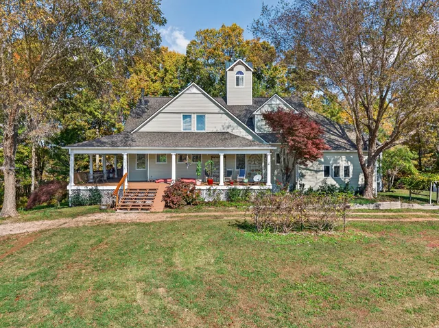 a front view of a house with a garden and trees