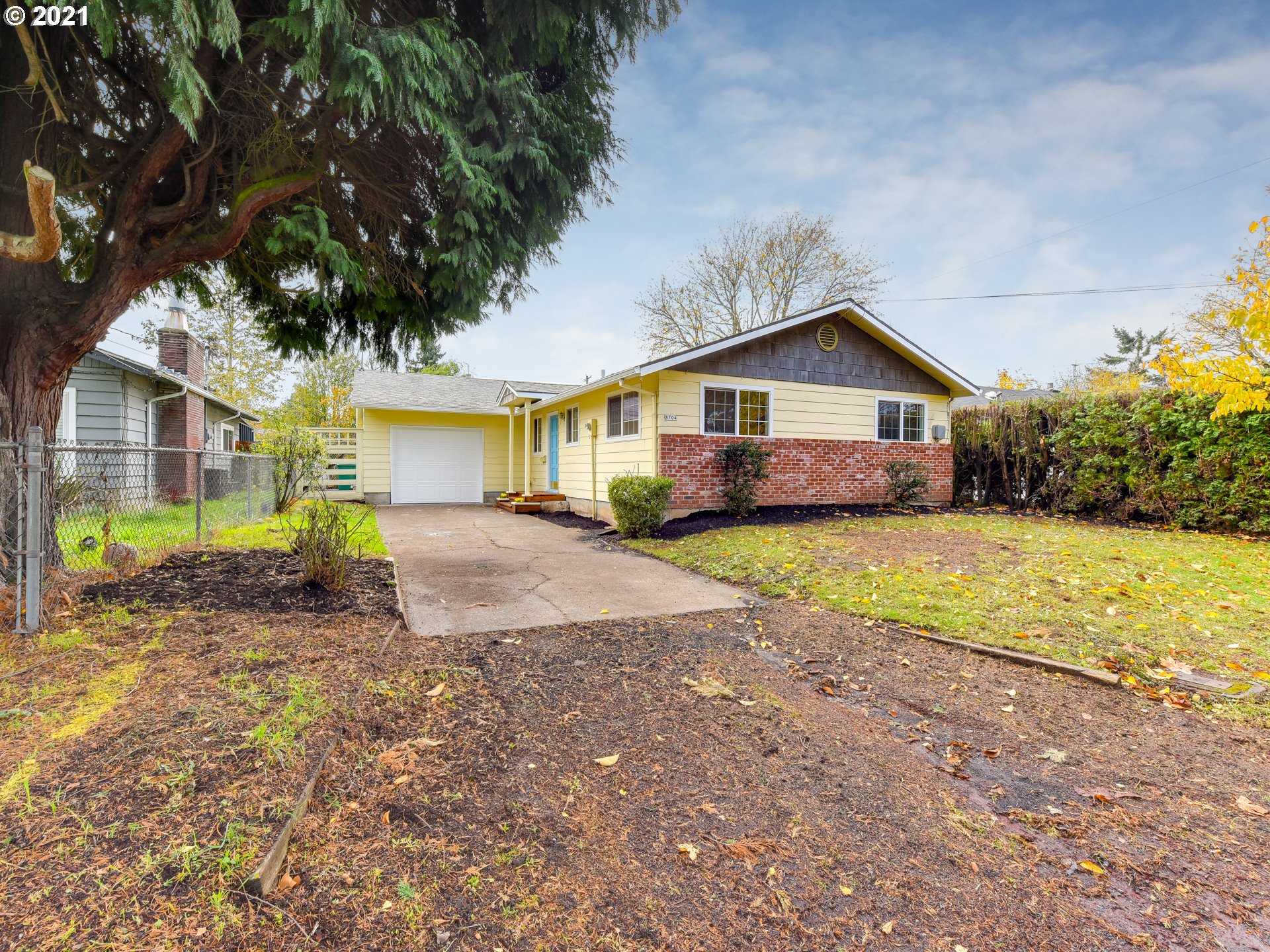 a view of a yard in front of a house with large trees