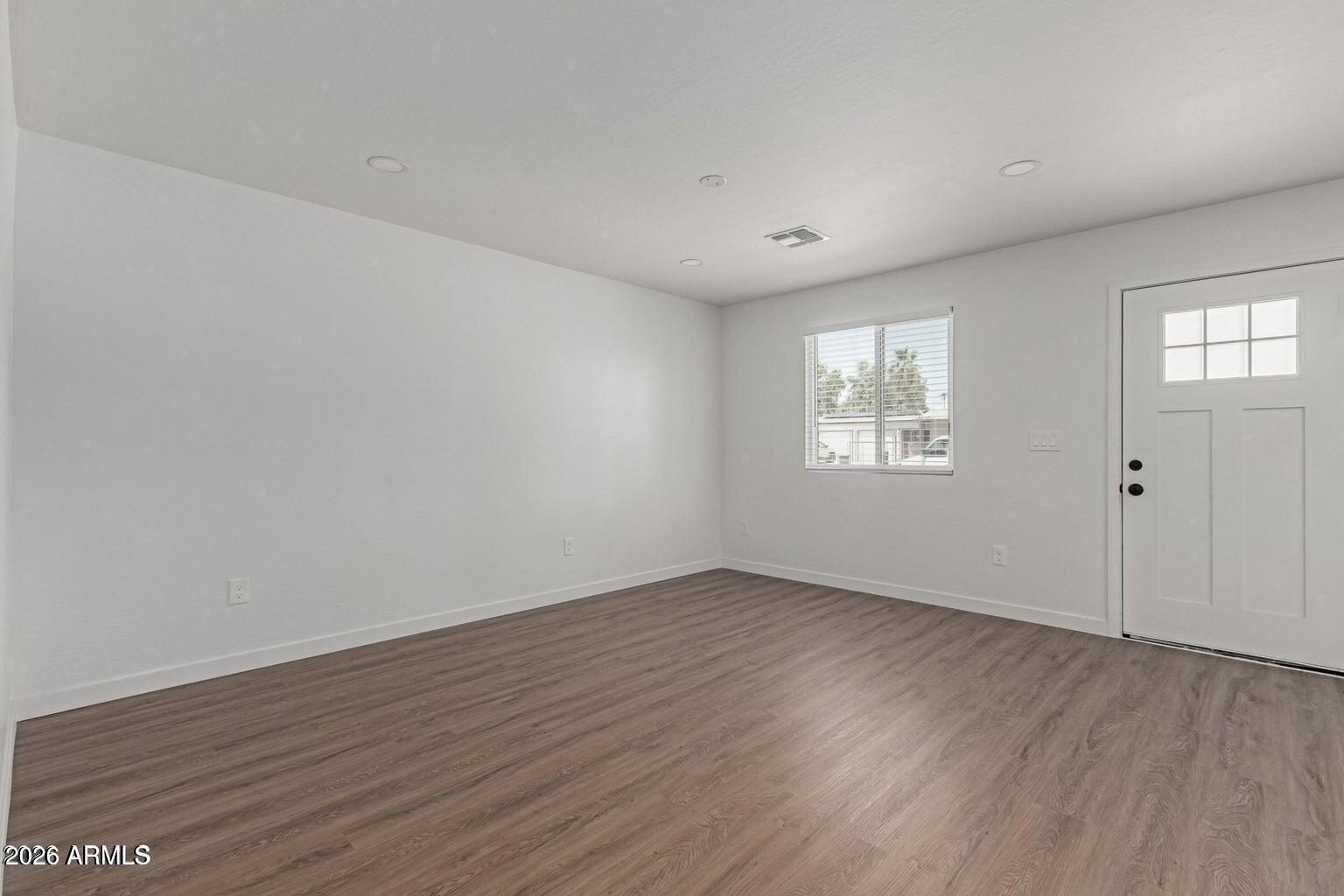 450 South Crismon Road, Unit 2 Mesa, AZ 85208 - Photo 2 of 21 a view of an empty room with wooden floor and a window
