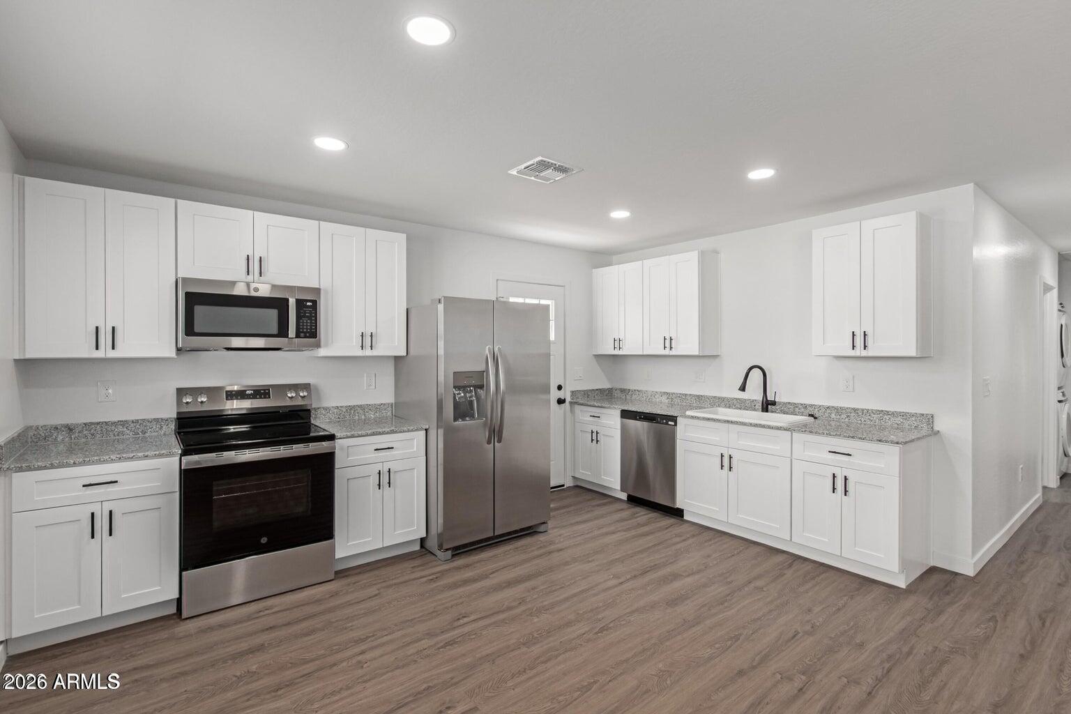 450 South Crismon Road, Unit 2 Mesa, AZ 85208 - Photo 3 of 21 a kitchen with granite countertop white cabinets and stainless steel appliances