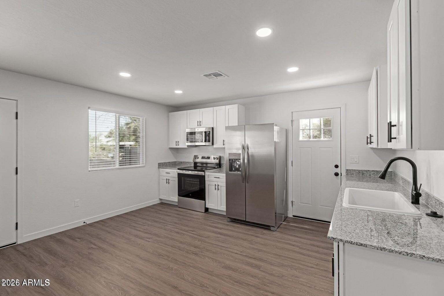 450 South Crismon Road, Unit 2 Mesa, AZ 85208 - Photo 4 of 21 a kitchen with granite countertop a refrigerator and a sink