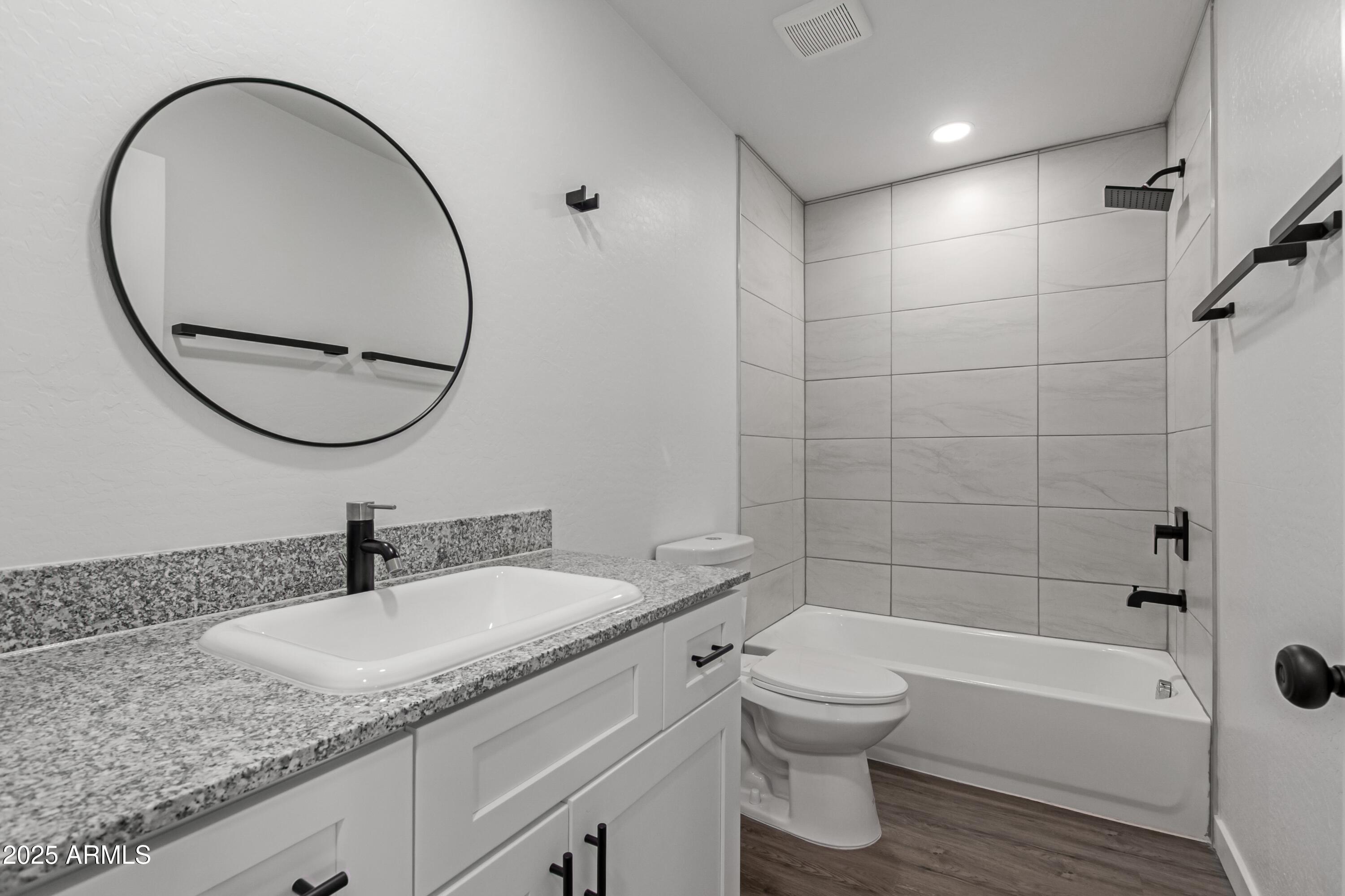 450 South Crismon Road, Unit 2 Mesa, AZ 85208 - Photo 9 of 21 a bathroom with a granite countertop toilet a sink and a mirror