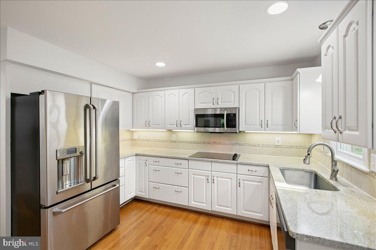 10741 Midsummer Drive Reston, VA 20191 - Photo 28 of 53 a kitchen with stainless steel appliances granite countertop a refrigerator sink and white cabinets