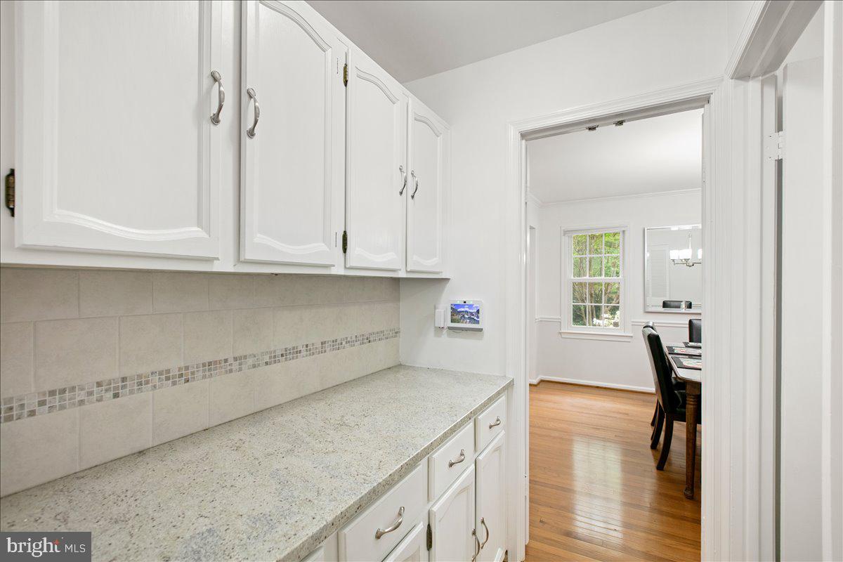 10741 Midsummer Drive Reston, VA 20191 - Photo 30 of 53 a kitchen with granite countertop white cabinets and a wooden floor