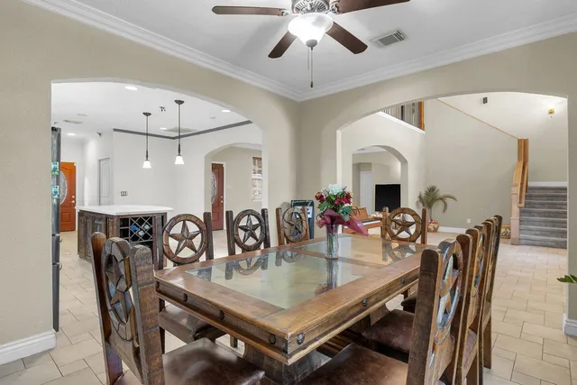 a kitchen with stainless steel appliances kitchen island granite countertop a table chairs in it and a window
