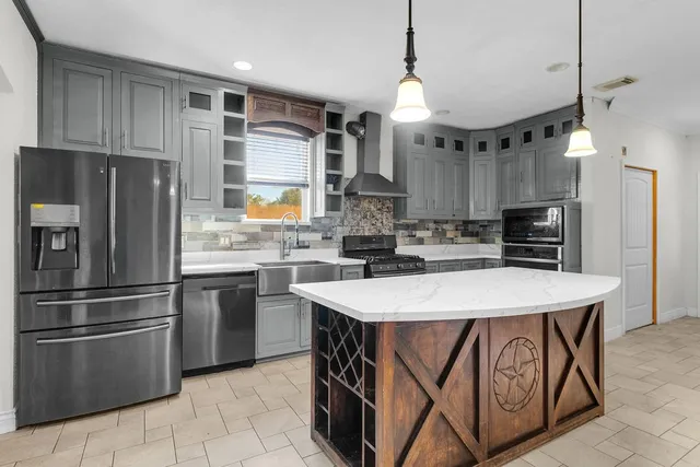 a kitchen with stainless steel appliances granite countertop a sink a stove and a refrigerator