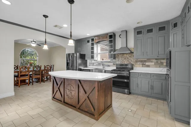 a kitchen with stainless steel appliances granite countertop a sink a stove and a refrigerator