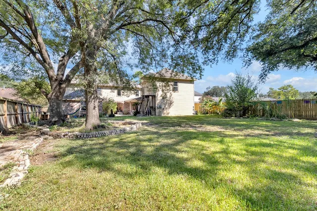 a view of a yard with plants and trees