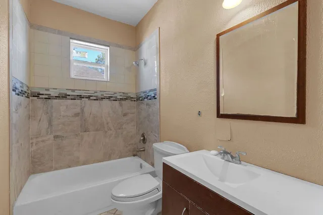a bathroom with a sink mirror toilet and bathtub