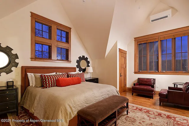 a bedroom with a bed and a dresser next to a window