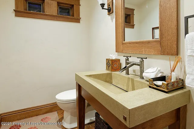 a bathroom with a sink a toilet and a mirror