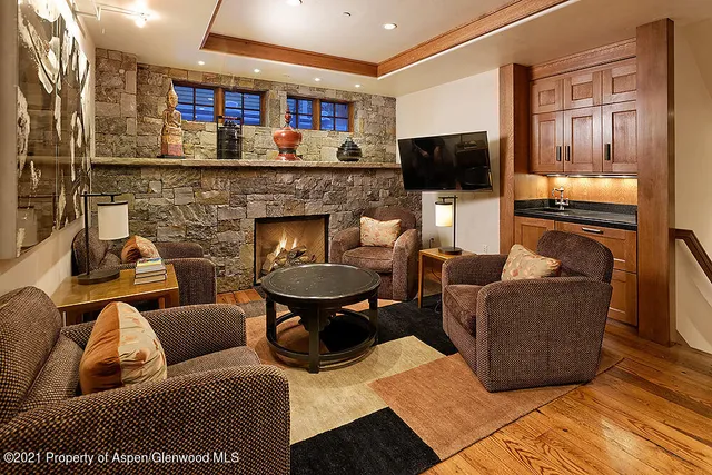 a living room with furniture a flat screen tv and a fireplace